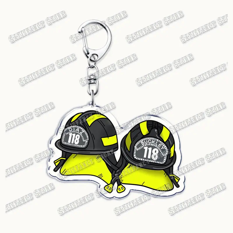 A clear acrylic 9-1-1 tv show keychain featuring two cartoon firefighter helmets in black and bright yellow with white number 118 on the front designed as a firefighter gift.