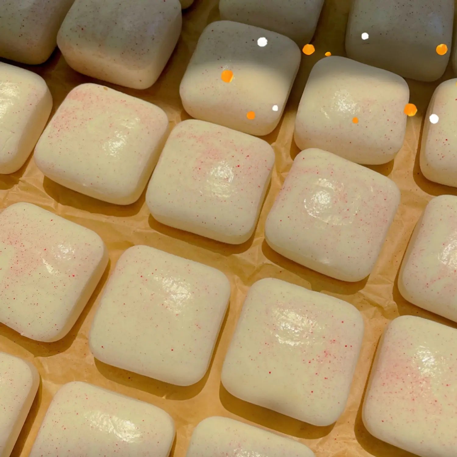 pièces de mini toast à dégagement lent, jouet sensoriel d’agitation, de forme carrée, en blanc cassé avec une légère teinte rosée et de fines mouchetures rouges, vues de face