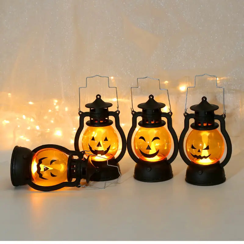 季節装飾用の、発光するオレンジ色のパンプキン顔を備えたブラックメタル製ハロウィンかぼちゃLEDランタンの4点セット