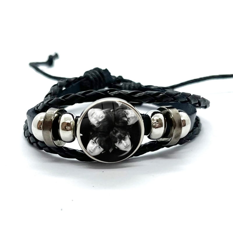 Black braided leather Beatles bracelet with silver-toned metal beads and a circular glass dome charm featuring a black and white photo of the band.