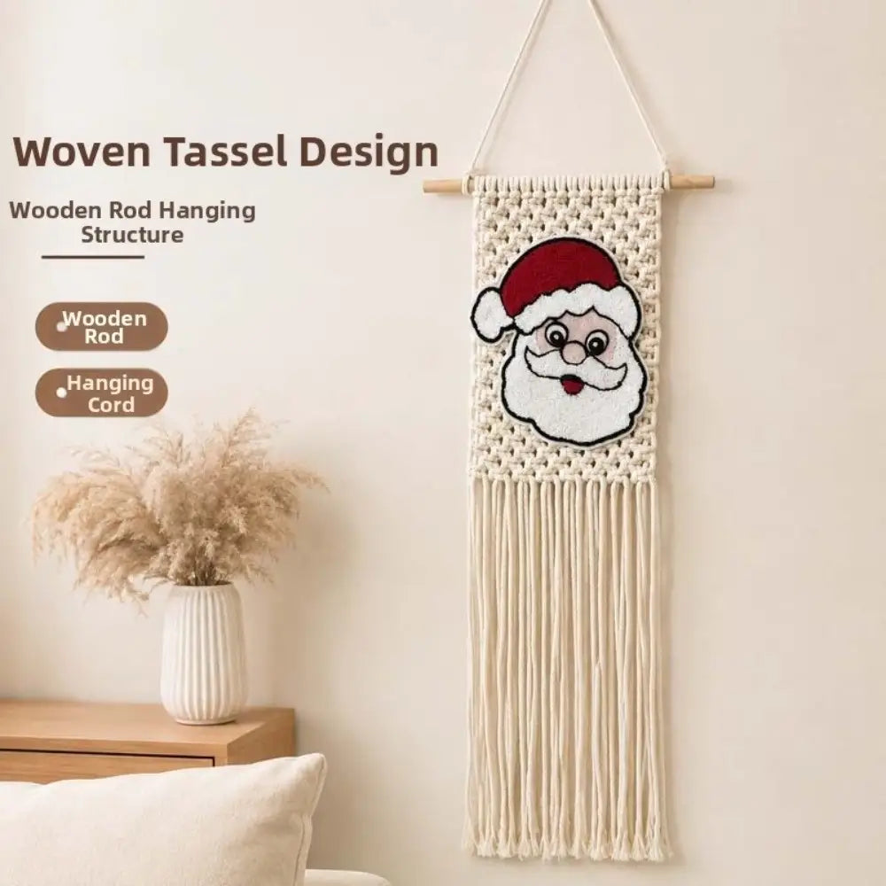 Cream-colored macrame Christmas wall hanging tapestry featuring a knitted Santa Claus face with red hat and white beard suspended by wooden rod and tassels.