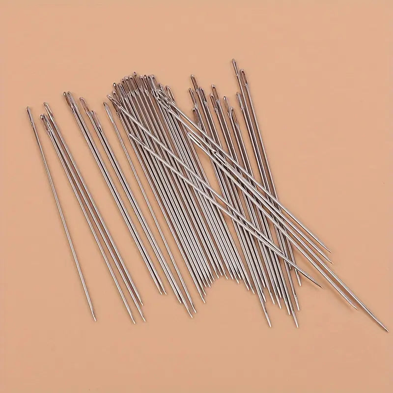 a set of slender metallic large eye sewing needles with pointed tips and smooth shafts for elderly use 40 pack