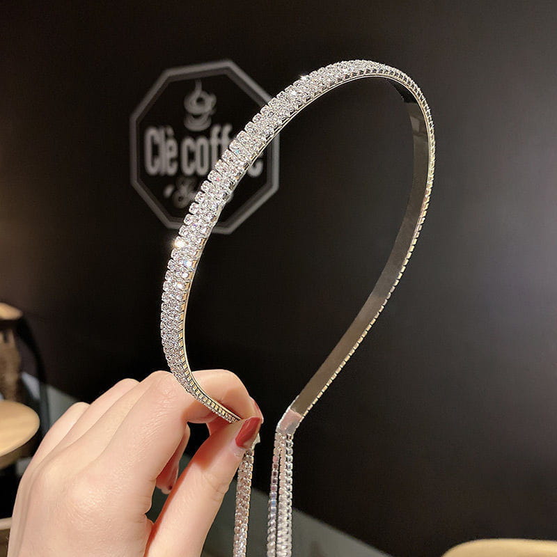 A silver-toned crystal rhinestone tassel headband for women featuring a continuous row of clear sparkling crystals along its curved edge.