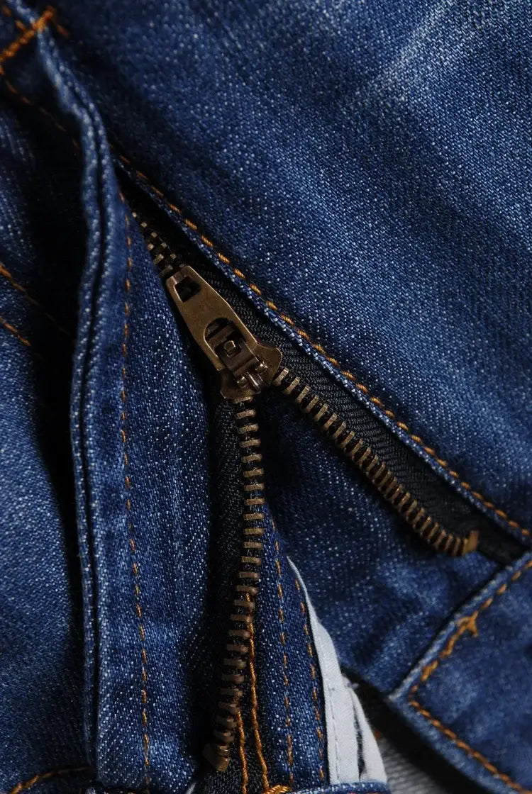 Men’s flared denim jeans bootcut casual pants in dark blue denim fabric featuring a brass-colored zipper and contrasting orange stitching.