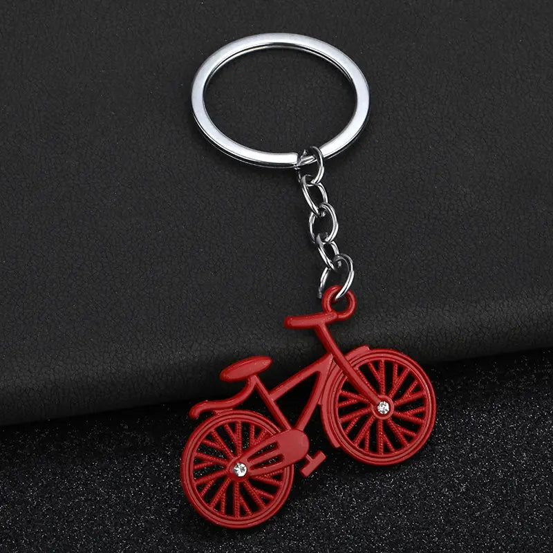 Red bicycle keychain charm set with silver metal ring and chain featuring clear rhinestones on the wheels.