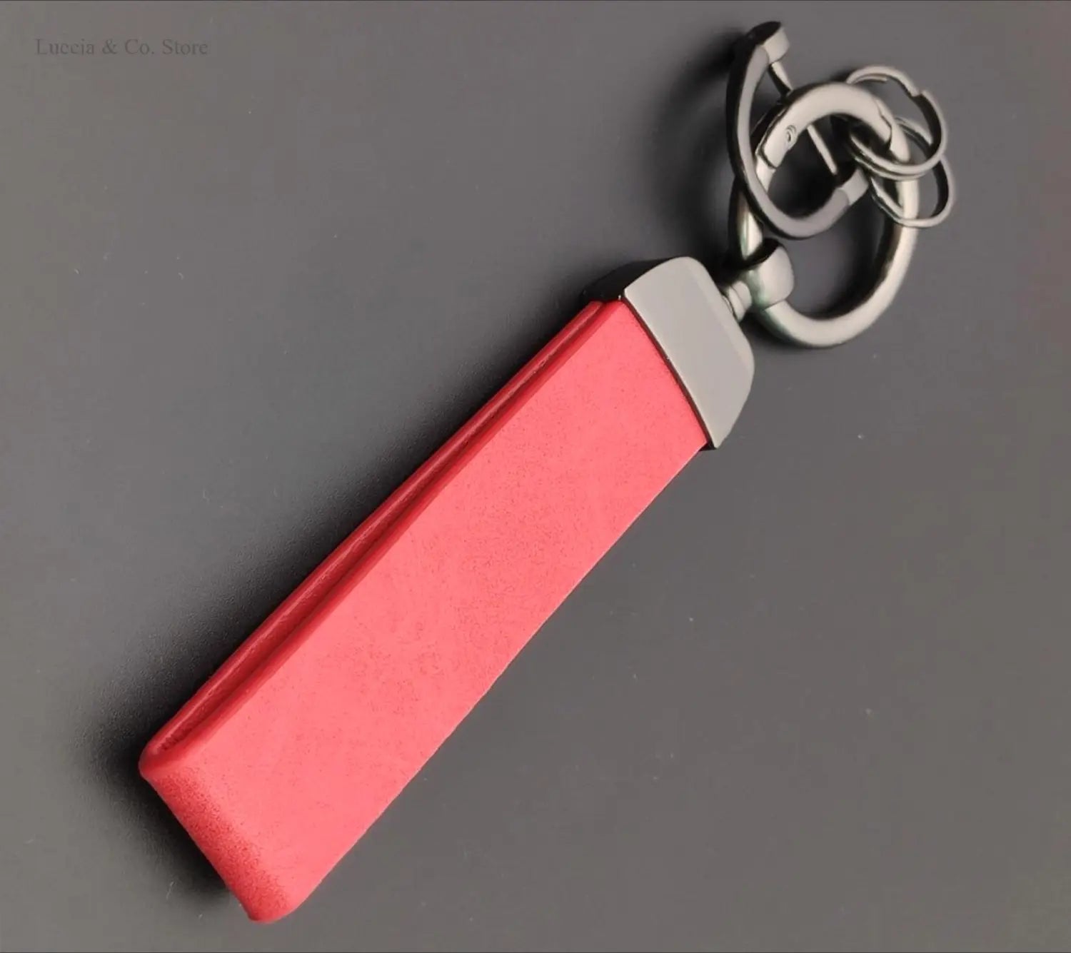 A sleek vibrant red leather custom logo car keychain with a polished silver metal clasp and ring assembly for personalized use.