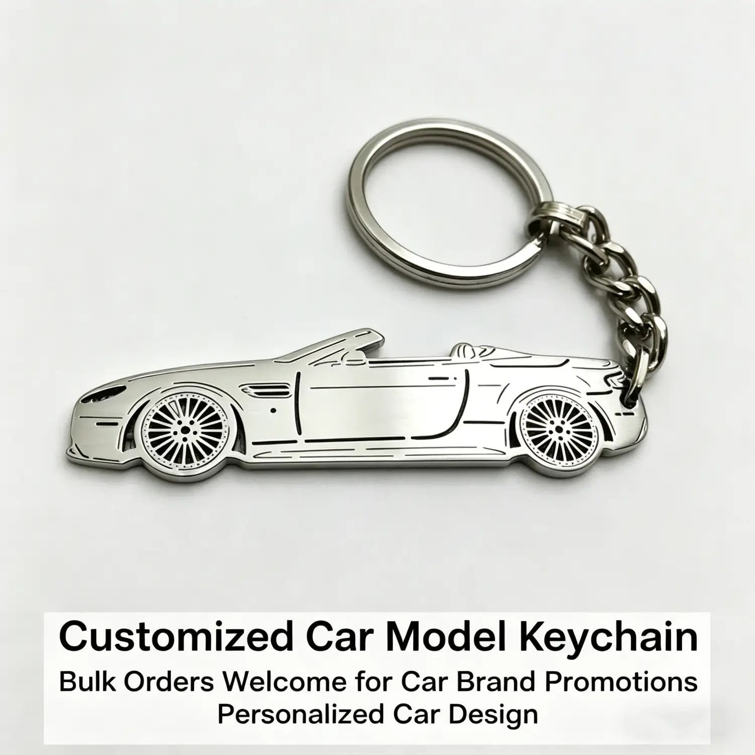 Silver metallic custom car model keychain shaped like a convertible sports car with detailed wheels and body lines used as a personalized vehicle key pendant.