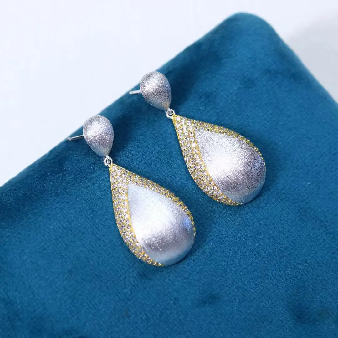 Ohrringe mit silbernen Tropfenquasten in Silber- und Gold-Vermeil mit einer strukturierten, matten Oberfläche und Pavé-Diamantdetails entlang der Ränder.