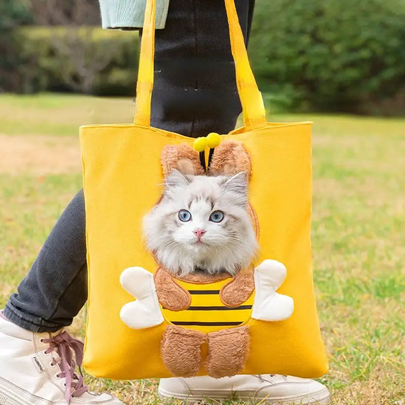 yellow canvas pet carrier bag with bee-themed design featuring a plush cat face peeking out from the front pocket designed for small dogs and cats with convenient mouth length opening