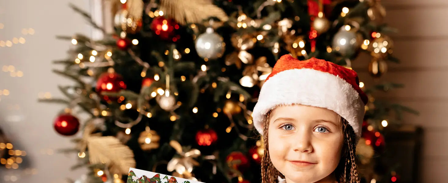 Ein junges Mädchen, das eine rote und weiße Weihnachtsmannmütze mit geflochtenem Haar trägt und ein verpacktes Geschenk vor einem dekorierten Weihnachtsbaum hält; das Weihnachtsüberraschungs-Adventskalender-Bausteinset ist sichtbar.