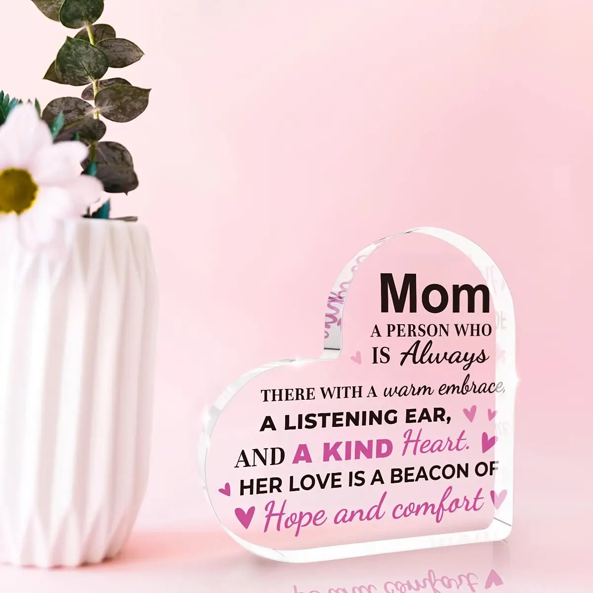 Clear heart-shaped acrylic plaque with engraved black and pink text reading mom a person who is always there with a warm embrace designed as a mom acrylic heart keepsake gift.