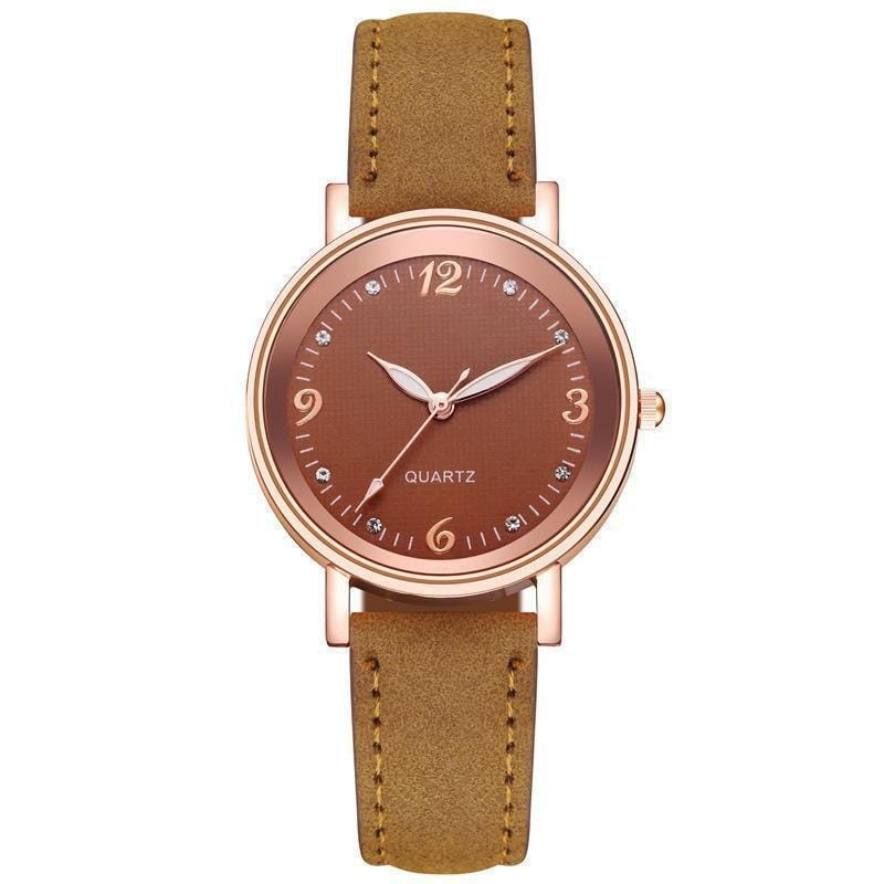 Women quartz watch with rose gold-toned dial, brown suede leather band, and diamond-like hour markers.