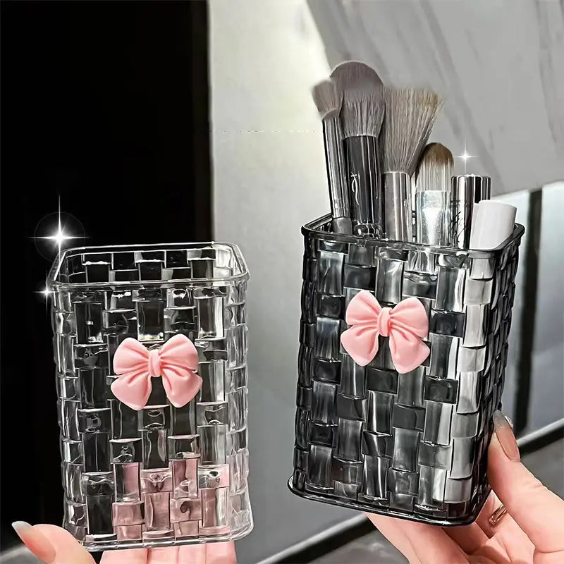 bow pen holder desktop storage organizer featuring clear and black woven mesh makeup brush holders each adorned with a soft pink satin bow for elegant desktop organization.