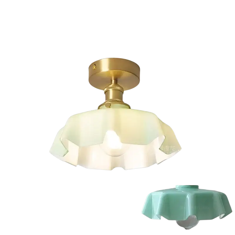Un luminaire de plafond de style vintage avec une base en métal à finition laiton, un abat-jour à jupe florale en verre blanc cassé à bords froncés et une tête de lampe en cuivre, montré depuis l’avant.