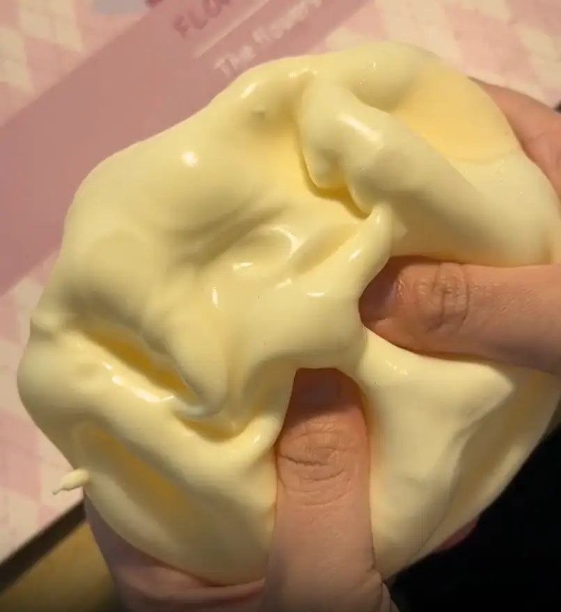 Un jouet à mâcher et à malaxer en forme de fromage jaune pâle, fabriqué en slime extensible, façonné par les doigts pour soulager le stress et apaiser le stress lié au jouet.
