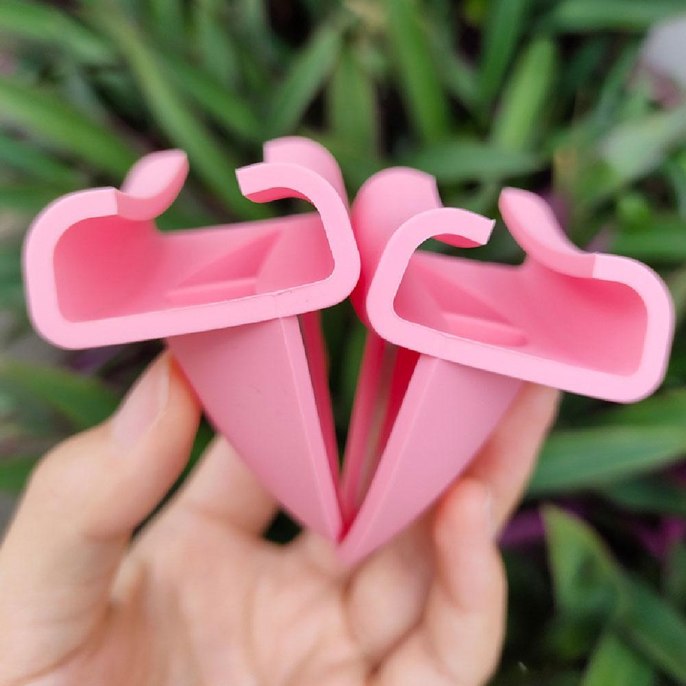 Attaches pour casque avec oreilles de chat en silicone rose, avec sommets en forme de cœur et bases triangulaires, conçues comme clips pour pots de plante