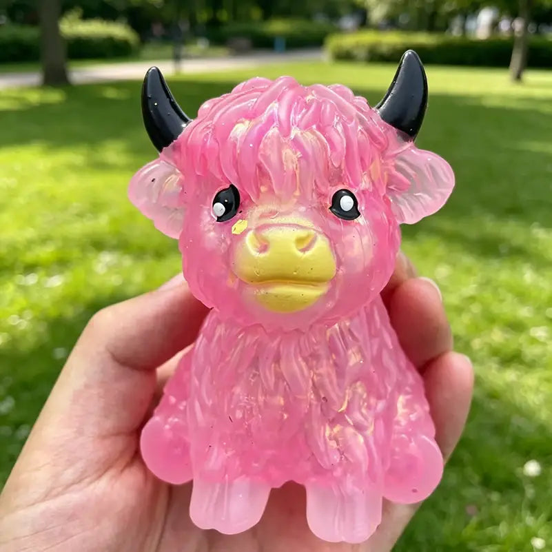 pink translucent plastic highland cow sensory fidget toy with black horns and yellow snout designed for stress relief