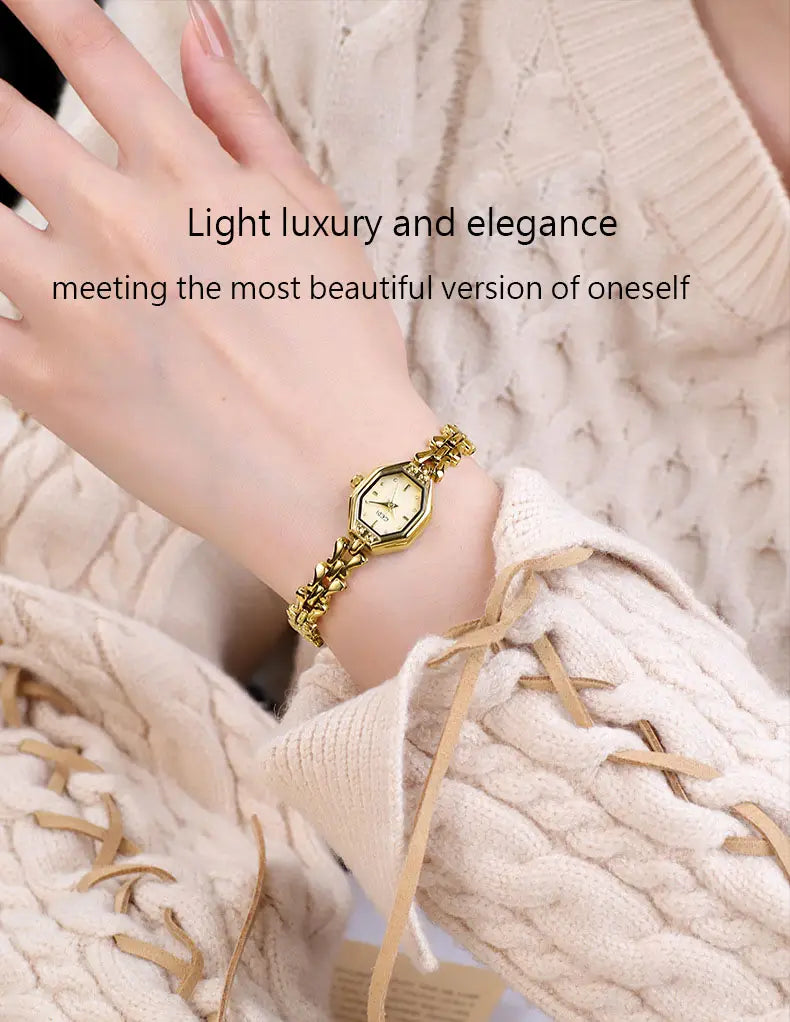 Gold-toned octagonal quartz watch with a delicate chain bracelet worn on a wrist for ladies luxury wear.