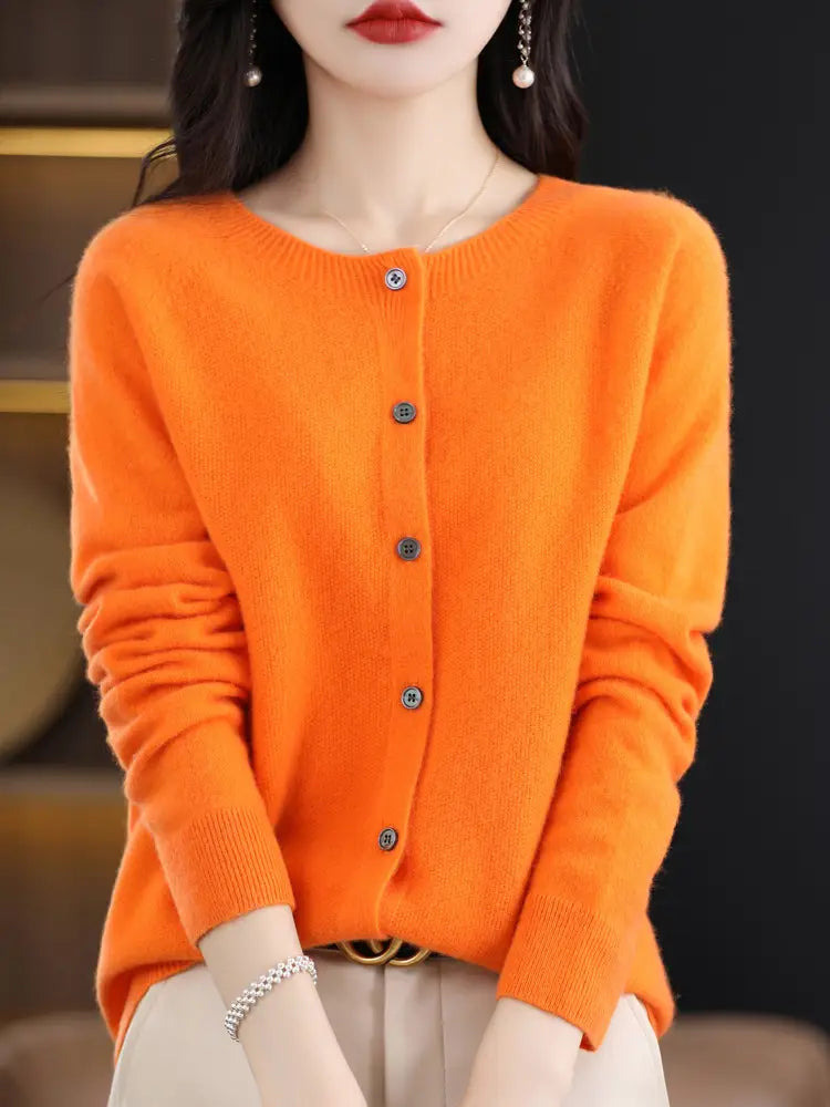 Vibrant orange merino wool cardigan women cashmere knit sweater with long sleeves dark buttons and round neckline.