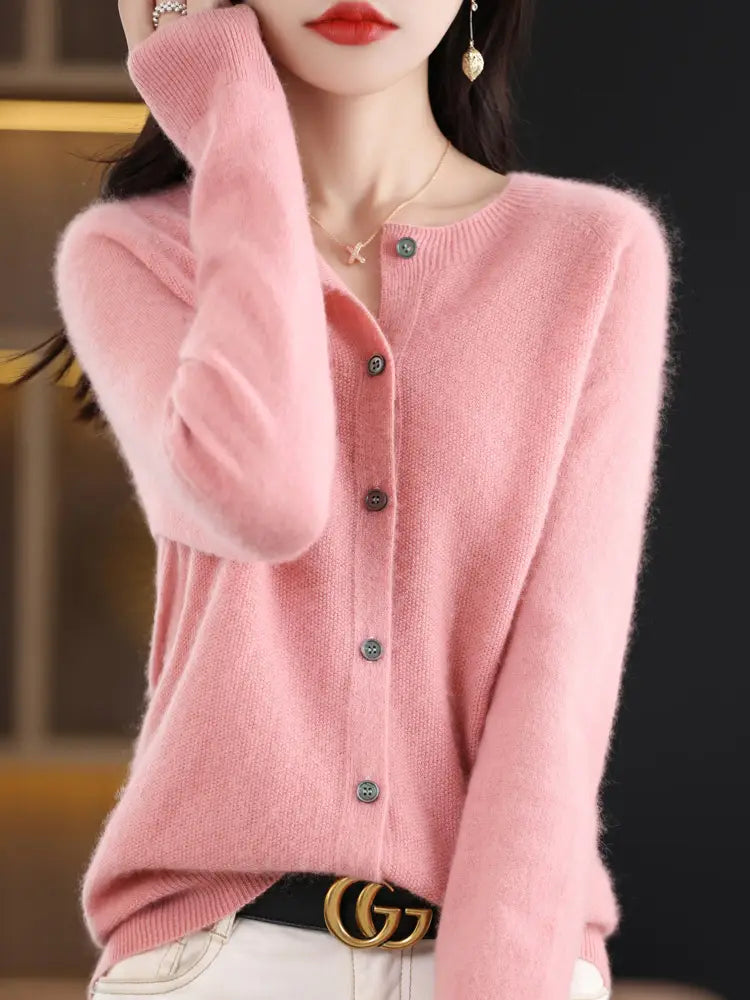 A soft pink merino wool cardigan for women featuring long sleeves, a round neckline, and dark green buttons in a cashmere knit design.