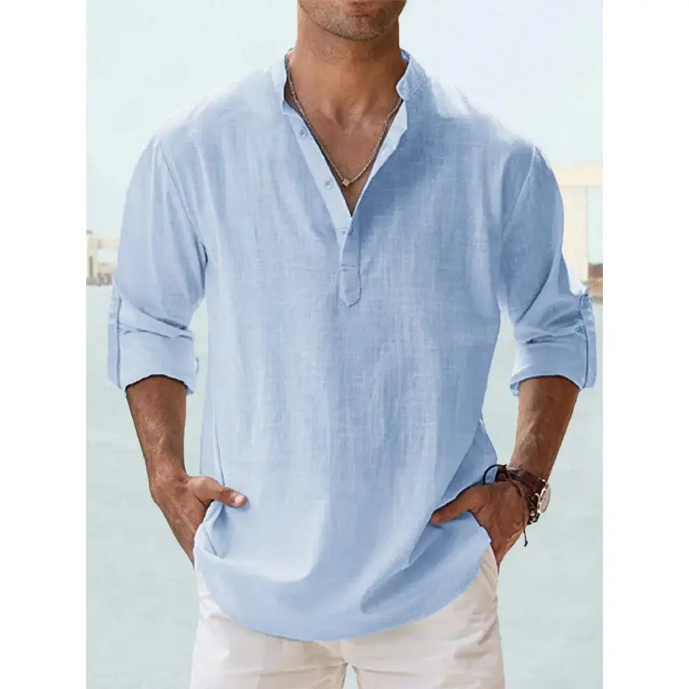 Chemise en lin henley bleu clair à manches longues pour homme, avec poignets retroussés et patte boutonnée, adaptée à une tenue décontractée d’été à la plage.