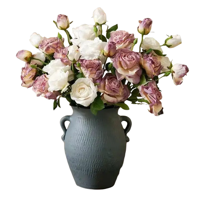 A rustic blue ceramic vase with dual handles holds a burnt edge rose bouquet of white and mauve roses viewed from front