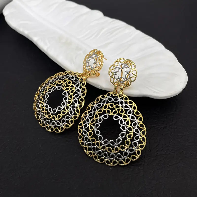 Boucles d’oreilles pendantes en filigrane bicolore or et argent, avec des motifs circulaires délicats en dentelle, pour femmes.