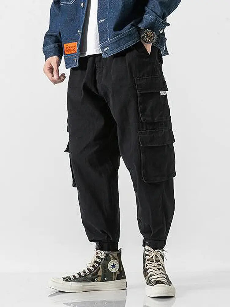 Pantalon jogger cargo noir pour hommes, doté de plusieurs poches et d’une taille à cordon de serrage en tissu résistant, adapté à un usage décontracté.