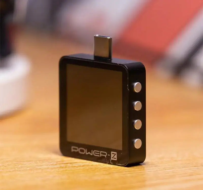 Black rectangular km003c chargerlab usb pd3.1 power tester with a matte finish, four silver buttons along its side, and a usb-c port on top supporting protocol pps 50v.