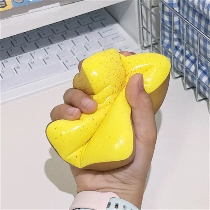 Jouet anti-stress en forme de toast moelleux jaune vif tacheté, couleur macaron, avec une texture souple et malléable, conçu pour soulager le stress.