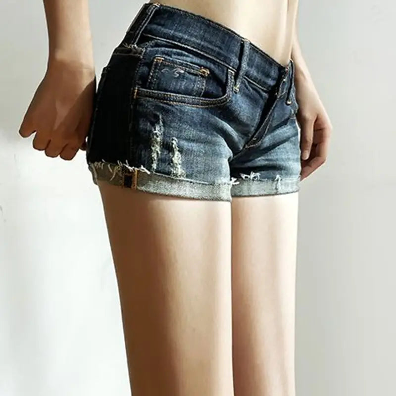 Women dark blue denim shorts slim fit featuring dark-wash material with frayed rolled cuffs and a distressed design.