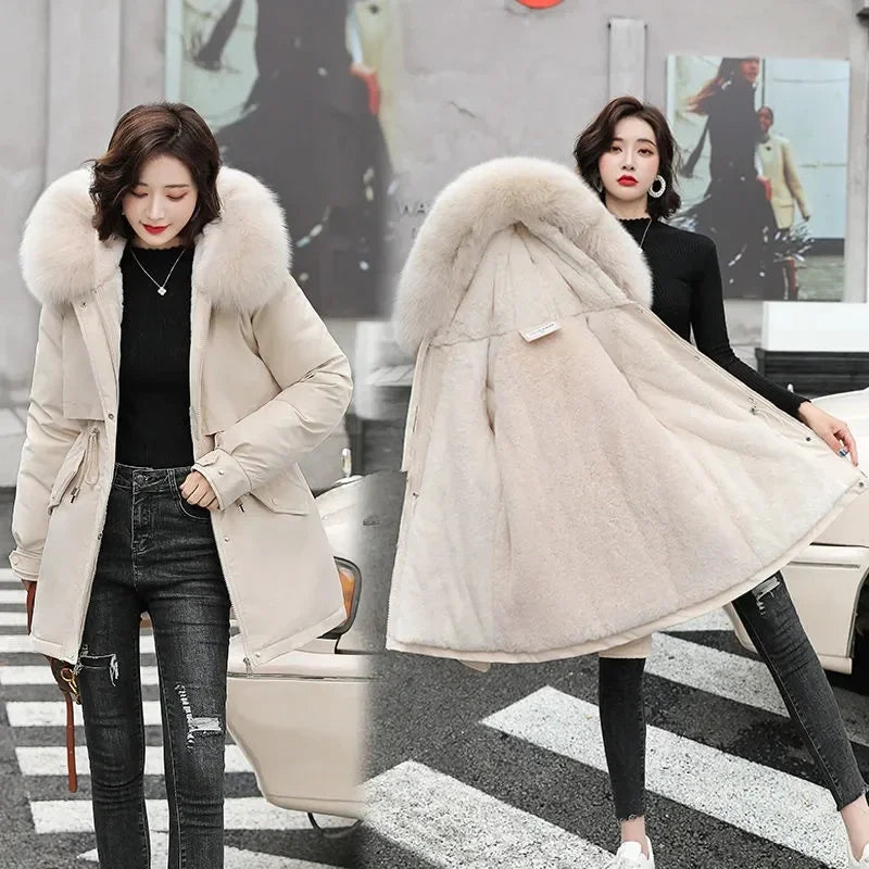 Parka d’hiver à capuche en fausse fourrure beige pour femmes, présentant un design matelassé et une capuche en fausse fourrure claire doublée et rembourrée.