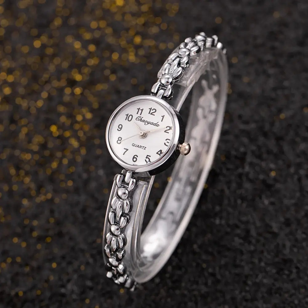 Silver-toned quartz ladies bracelet watch with a delicate beaded chain bracelet and a round white dial featuring black numerals.