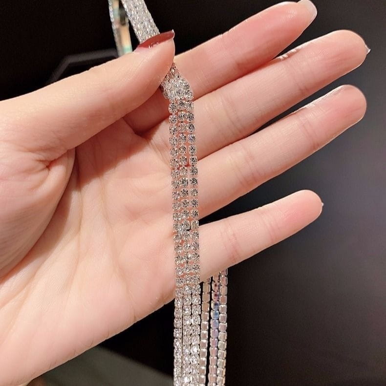 A crystal rhinestone tassel headband for women featuring a sparkling silver rhinestone chain with multiple rows of clear faceted crystals set in a delicate metal frame.