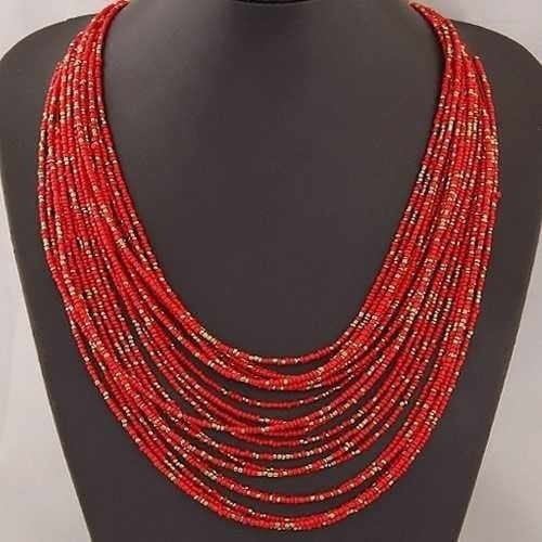 A vibrant red boho multi-layer bead statement necklace with subtle gold accents displayed on a black mannequin bust.