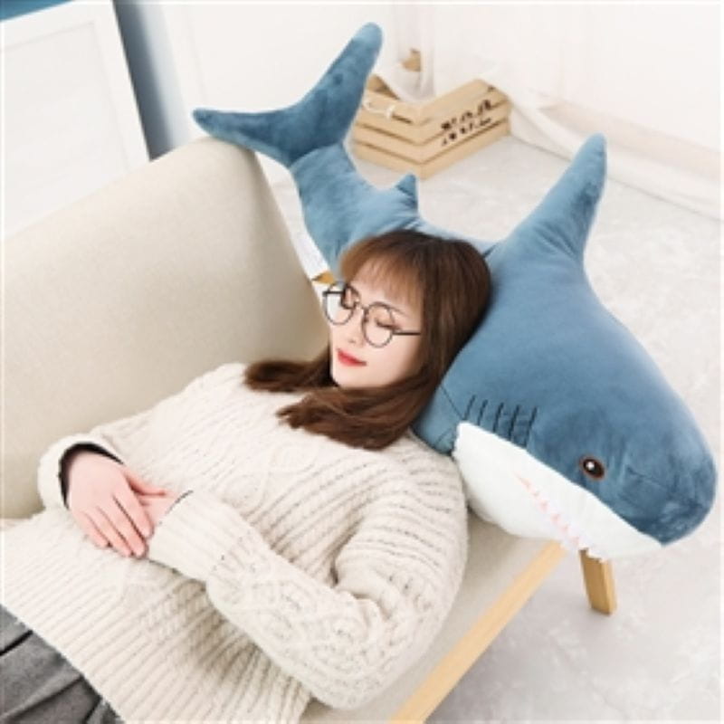 Plush blue shark stuffed animal pillow features a soft white underbelly and detailed stitched eyes.