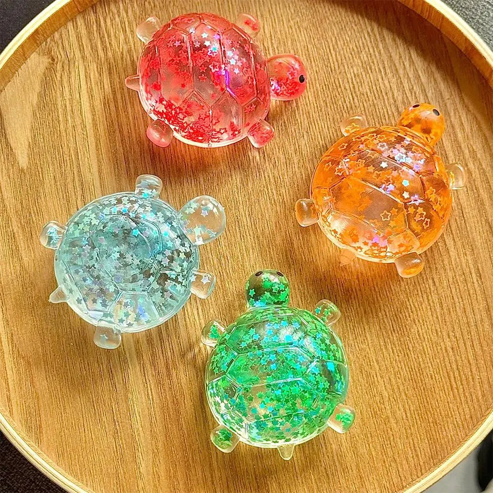 Vier farbenfrohe durchscheinende Schildkröten-Spielzeug-Fidget-Spielzeuge mit glitzernden Sternmustern in weichen Knautsch-Entlastungsbällen.