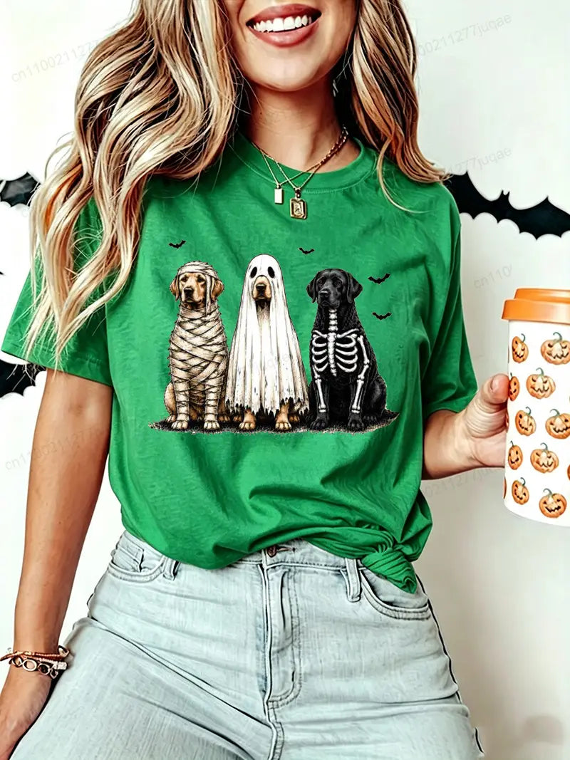 Green short sleeve women’s t-shirt featuring a halloween dog graphic with three dogs dressed as a mummy ghost and skeleton.