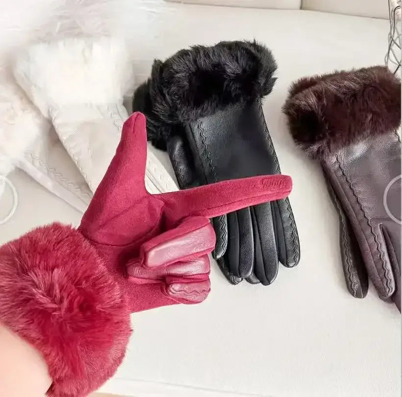 A plush red women’s fur-lined winter leather glove with suede-like texture and stitched detailing showing the back side.