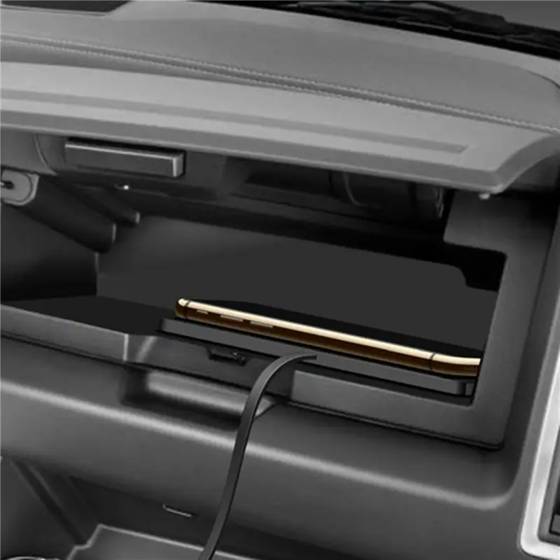 a gold-colored smartphone resting in a black car center console storage compartment alongside a 15w fast wireless car charger pad designed for convenient in-car charging