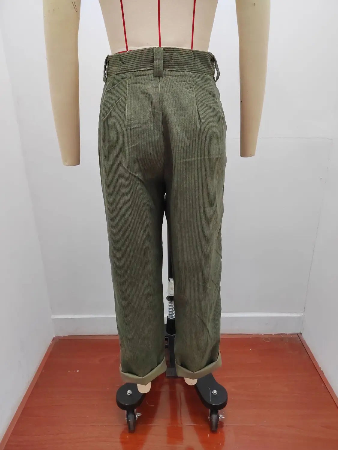 Pantalon en velours côtelé vert olive taille haute ample avec bas retroussés, présenté de face