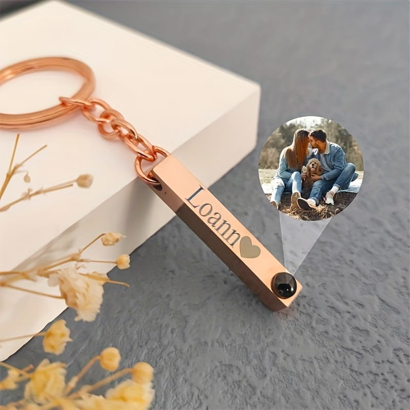 rose gold rectangular metal custom photo projection keychain personalized with engraved name loann and heart symbol featuring a small black circular compartment at one end