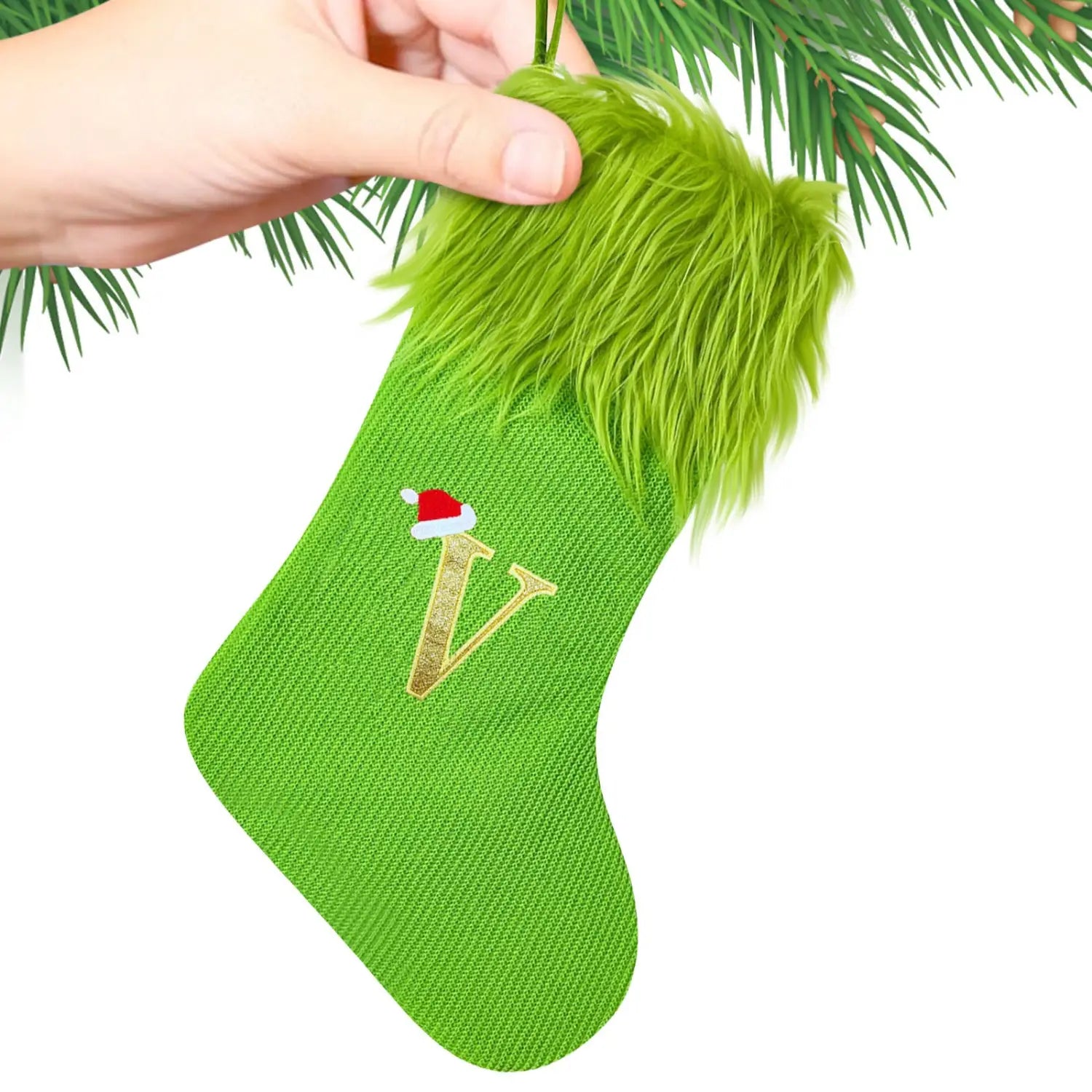 A vibrant green knitted Christmas stocking with a fluffy lime-green faux fur cuff and a gold-embroidered letter V topped with a miniature red and white Santa hat.