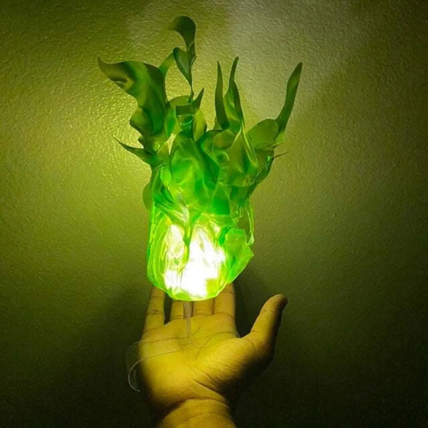 a glowing green translucent plastic plant-shaped lamp with leafy flame-like details featured as a floating fireball led halloween prop