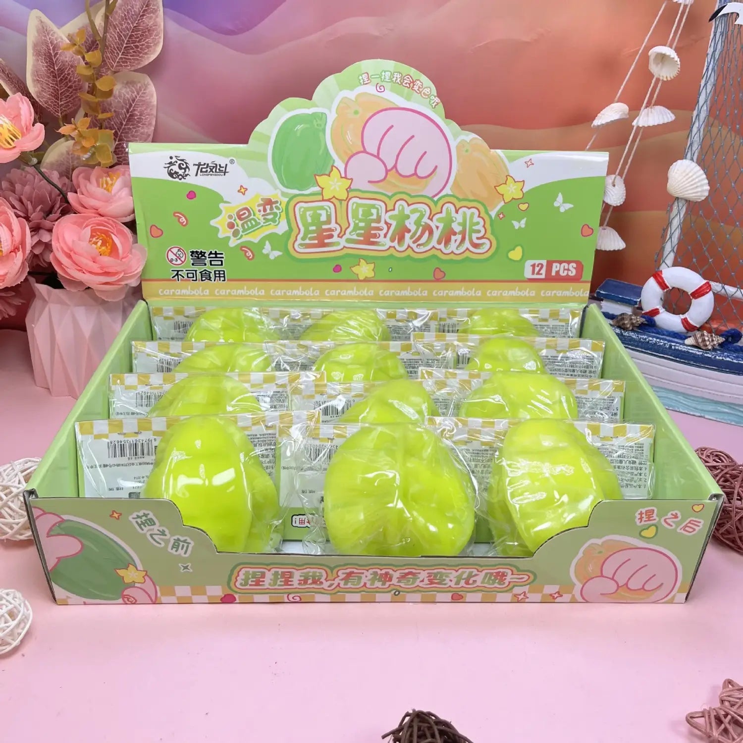 Juguetes blandos de fruta estrella que cambia de temperatura, color verde lima brillante, hechos de material suave, envasados en plástico transparente dentro de una caja de exhibición de cartón colorida.