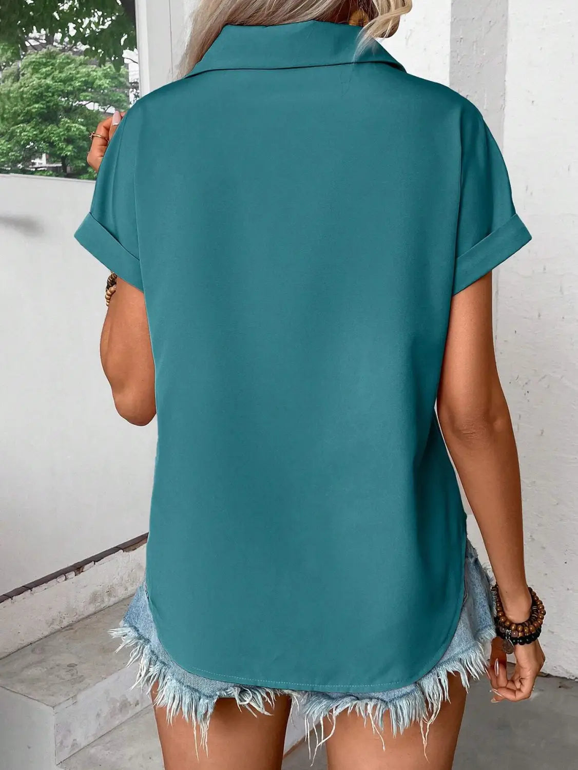 Teal short sleeve button up blouse for women with a collar and rolled cuffs highlighting the sleeve length detail.