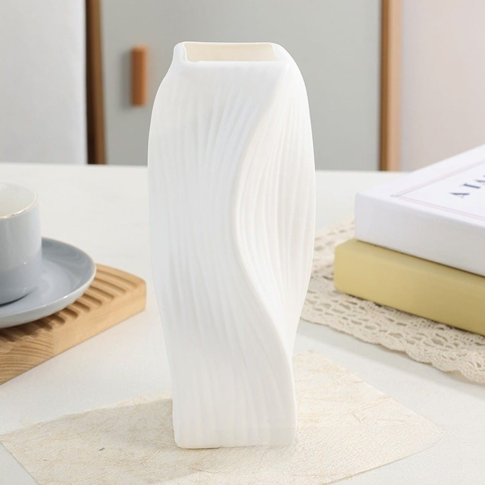 A sleek white ceramic Nordic wave plastic flower vase with a modern wavy design and vertical ridges for aesthetic home decor.