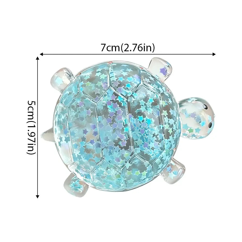 Ein durchscheinender blauer, mit Glitzer gefüllter Schildkröten-Spielzeug-Stressball mit einem sechseckigen Schalenmuster und klaren Plastikarmlimbs, entworfen als weiches Knautsch-/Fidget-Spielzeug zur Stresslinderung.