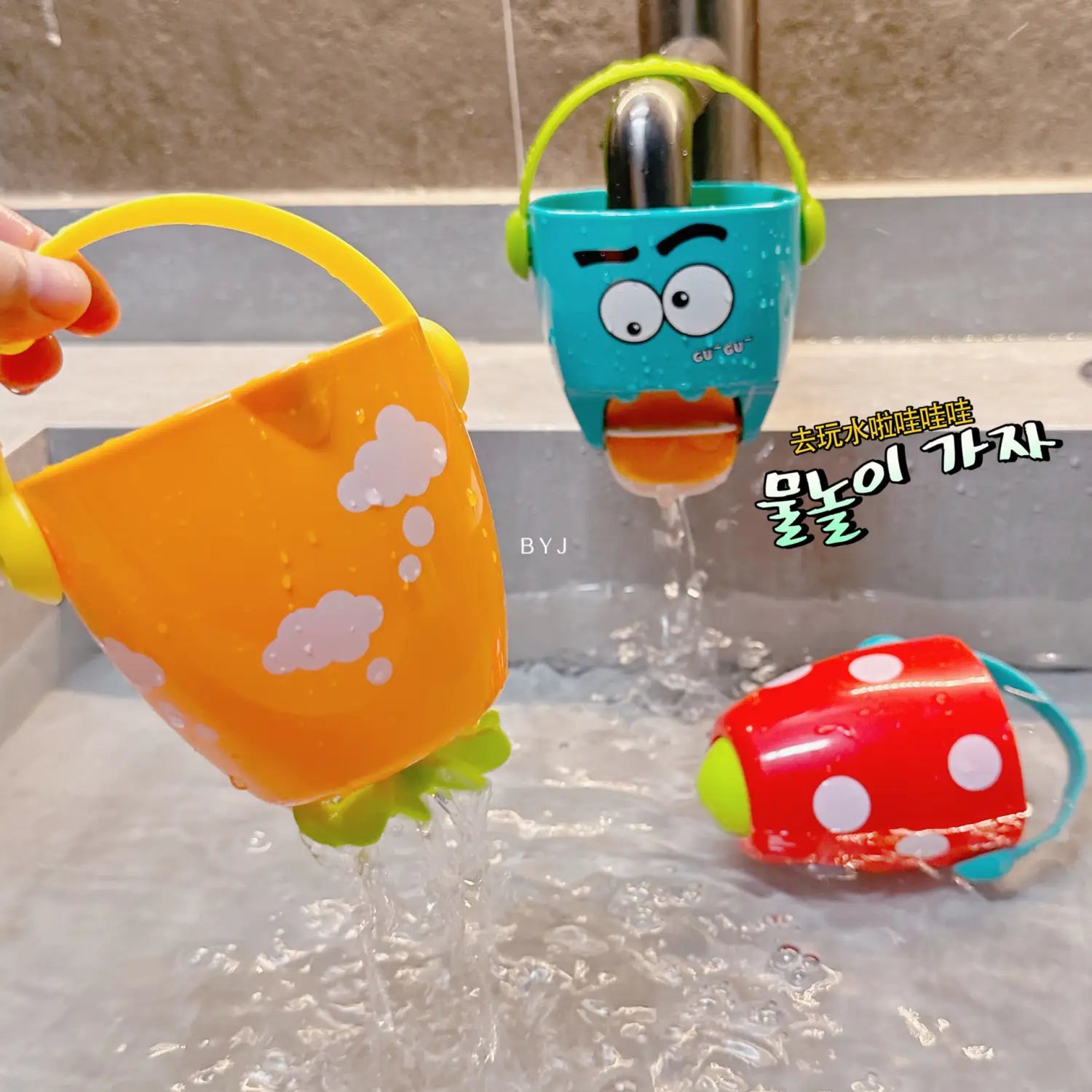 Hellorangefarbener Kunststoff-Badewannen-Eimer für Babys mit grünem Griff und bodenseitiger, blattförmiger Unterseite; mit weißen Wolken-Aufklebern als Wassersprühspielzeug-Set.