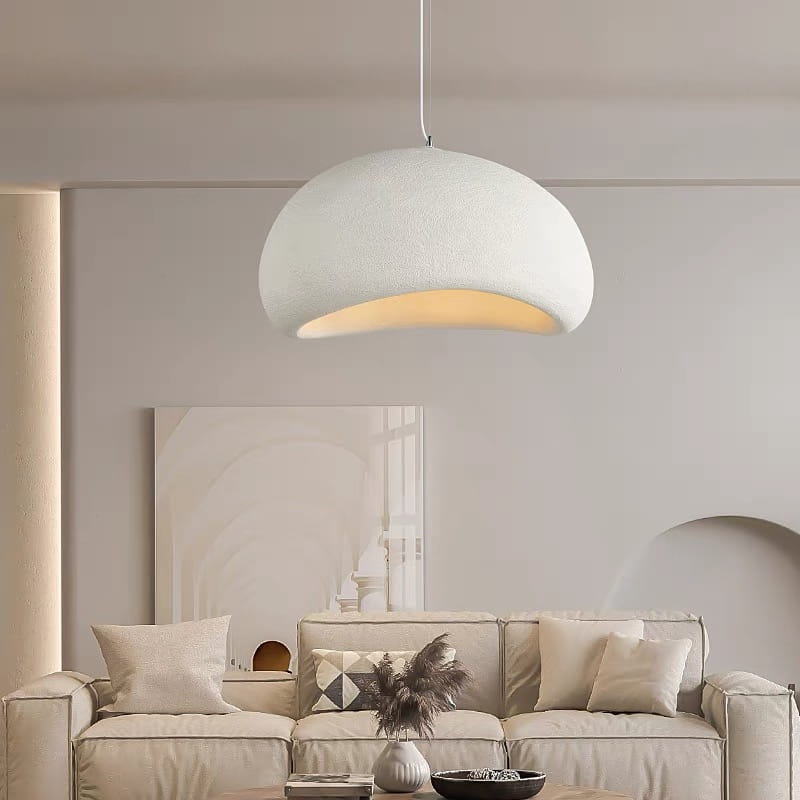 Una luminaria colgante moderna blanca con una pantalla de forma de cúpula con textura y un brillo interior cálido, diseñada para su uso en sala y comedor.